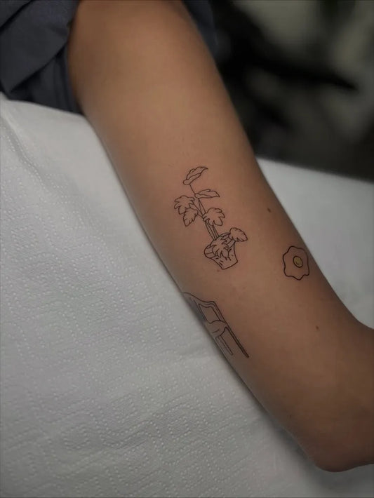 Small Minimalist Palm Tree and Egg on Women Arm Tattoo by @brisatattoomalaga