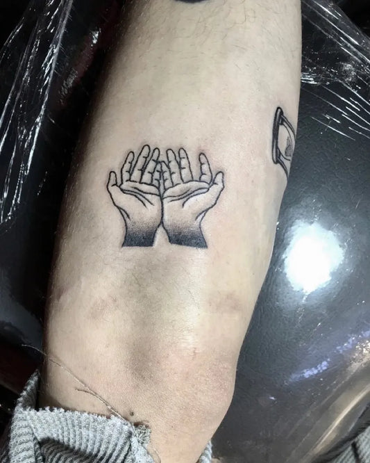 Small Minimalist Praying Hands on Men Arm Tattoo by @foxtrot.tattoo