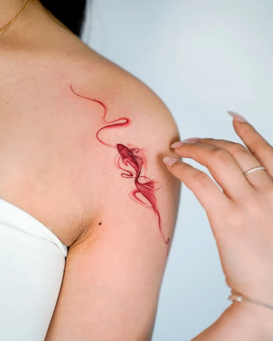 Small Minimalist Red Koi Fish Tattoo on Women Shoulder by @peria_tattoo