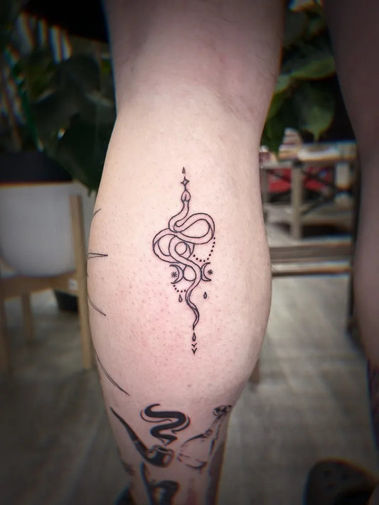 Small Minimalist Snake and Stars on Women Thigh Tattoo by @tatto_ojoanna