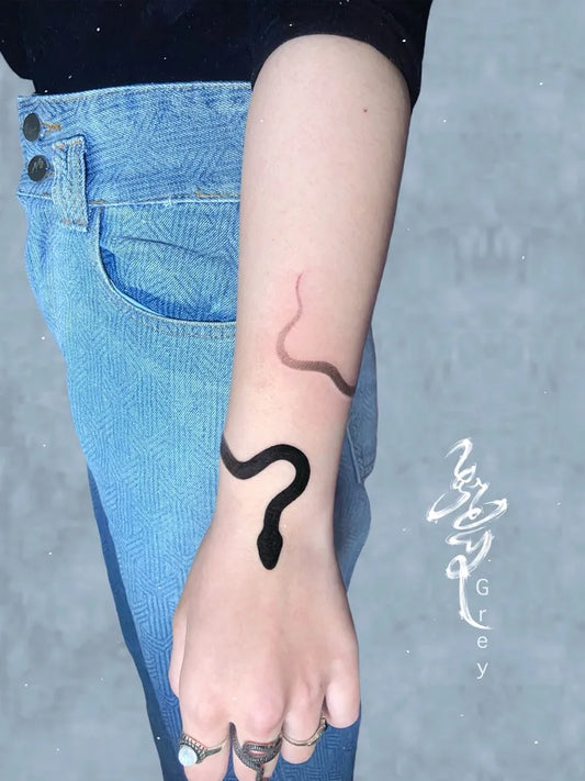 Small Minimalist Snake on Women Arm Tattoo by @grey3110.tattooist