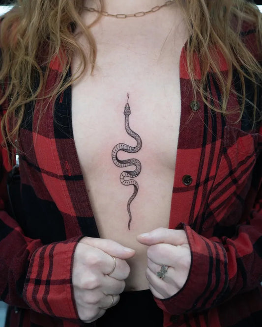 Small Minimalist Snake on Women Sternum Tattoo by @sebastian_tattoo