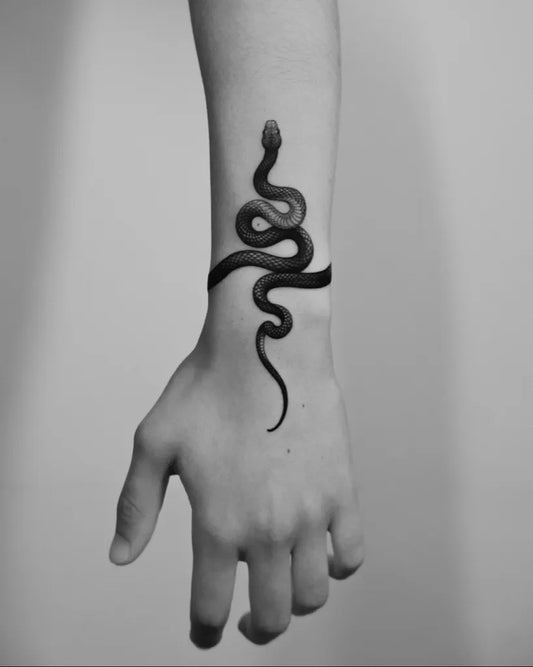 Small Minimalist Snake on Women Wrist Tattoo by @pawelindulski