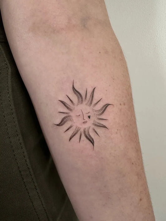 Small Minimalist Sun with Face on Women Arm Tattoo by @louka.tattooist