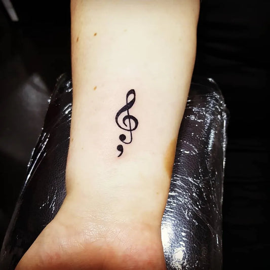 Small Minimalist Treble Clef Semicolon on Women Wrist Tattoo by @flowersandskulls27