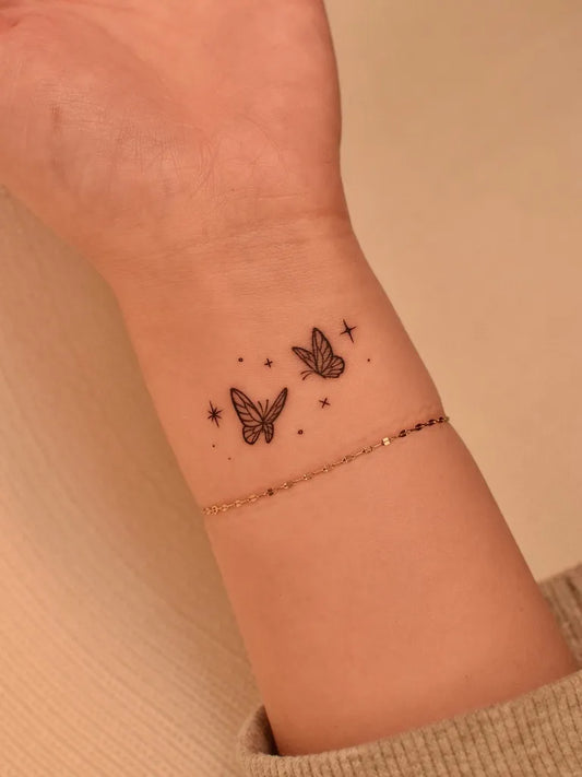 Small Minimalist Two Butterflies and Stars on Women Wrist Tattoo by @tinytattooinc