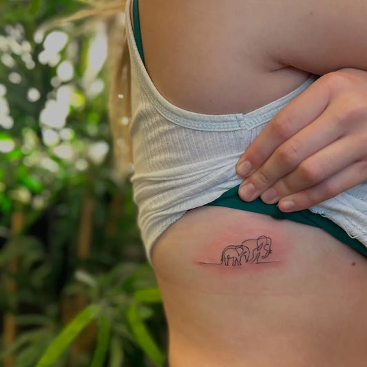 Small Minimalist Two Elephants Tattoo on Women Rib by @chlotattoos