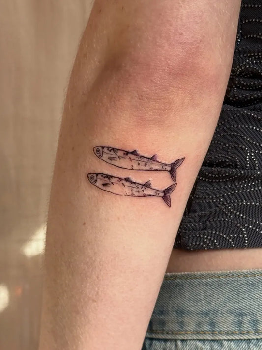 Small Minimalist Two Fish Tattoo on Women Arm by @stinky.tatts