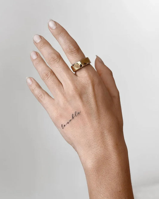 Small Minimalist Word on Women Hand Tattoo by @cha.tattoo