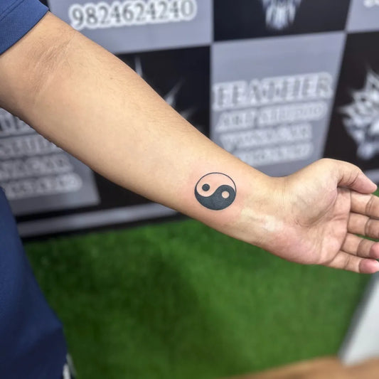 Small Minimalist Yin Yang Tattoo on Men Arm by @feather_art_studio_
