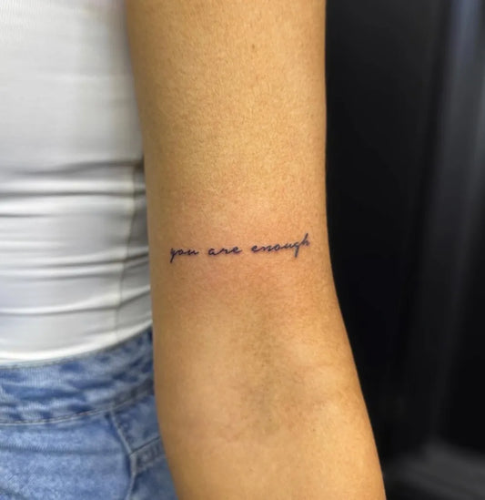 Small Minimalist You Are Enough Text on Women Arm Tattoo by @inklulu_