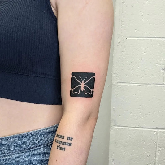 Small Negative Space Butterfly Tattoo on Women Arm by @molebulle