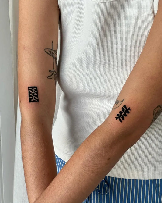 Small Negative Space Chinese Characters Tattoo on Women Arm by @stinky.tatts