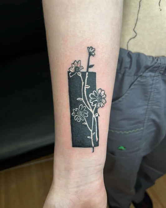 Small Negative Space Flowers and Stem Tattoo on Women Wrist by @benz.tattoos