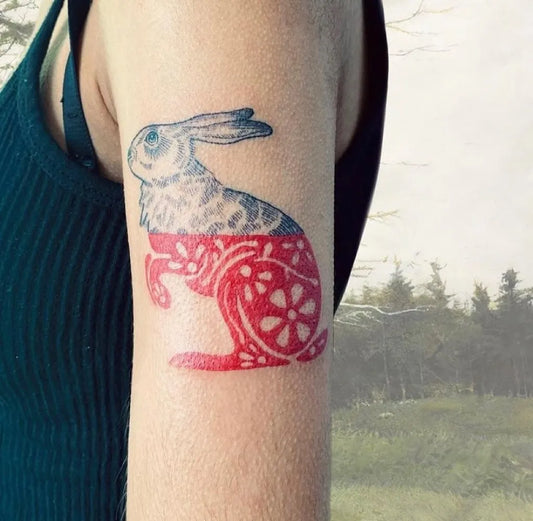 Small Negative Space Hare Tattoo on Women Arm by @hemlocktattoostudio