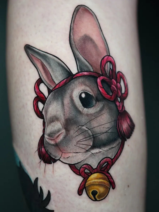 Small Neo Traditional Rabbit with Red Bow and Bell on Women Arm Tattoo by @marinazarallo_tattoo