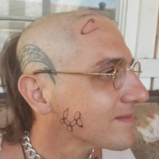 Small Neo Traditional Safety Pin Balloon Feather on Men Face Tattoo by @chainveil.tattoo