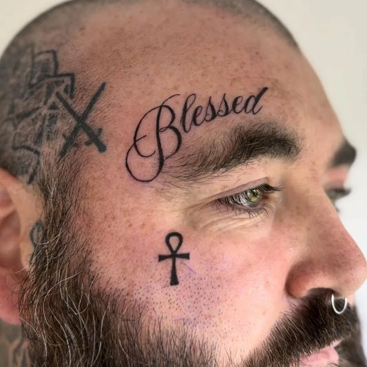 Small Neotraditional Blessed Ankh Cross on Men Face Tattoo by @tillypad_tattoo_studio