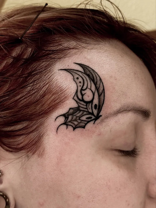 Small Neotraditional Butterfly on Women Face Tattoo by @suziruetattoo