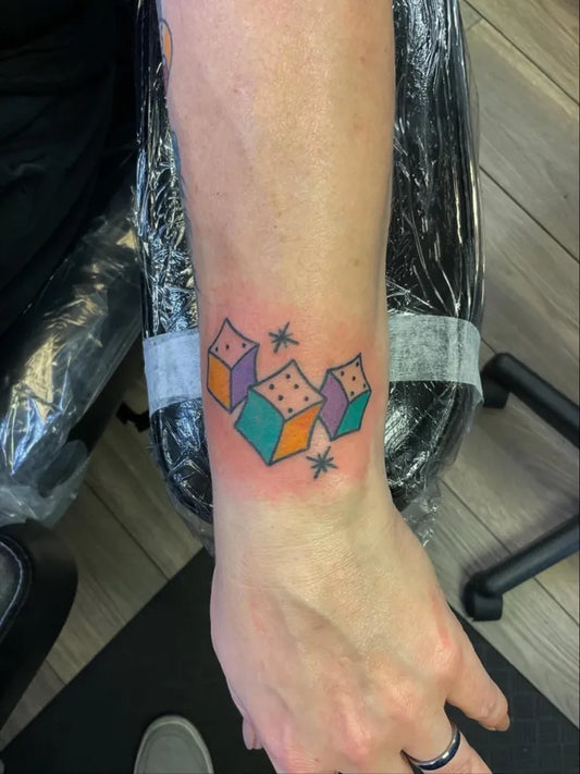 Small Neotraditional Dice Tattoo on Women Wrist by @matthew_inked