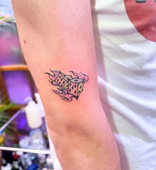 Small Neotraditional Dice with Flames Tattoo on Women Arm by @puff_channel