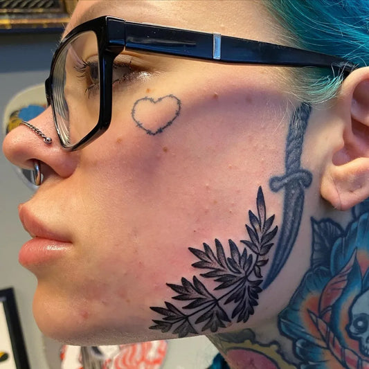Small Neotraditional Heart Dagger Leaves on Women Face Tattoo by @jontteritontteri