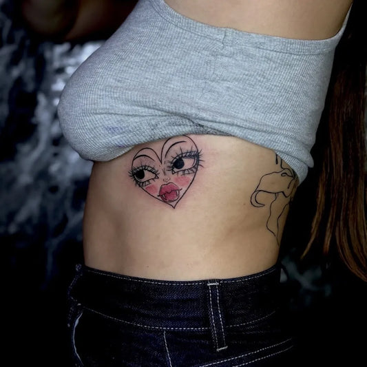 Small Neotraditional Heart Eyes Face on Women Rib Tattoo by @bluefox_tattoo