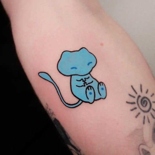 Small Neotraditional Mew Sun Pokemon Tattoo on Women Arm by @fimmtattooer