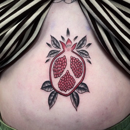 Small Neotraditional Pomegranate on Women Sternum Tattoo by @lauren.dtattoos