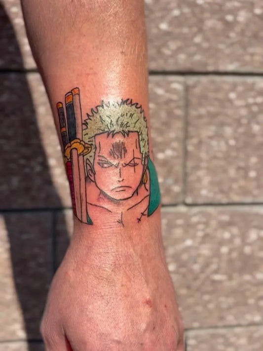 Small Neotraditional Roronoa Zoro on Men Wrist Tattoo by @bye.felishuhhh