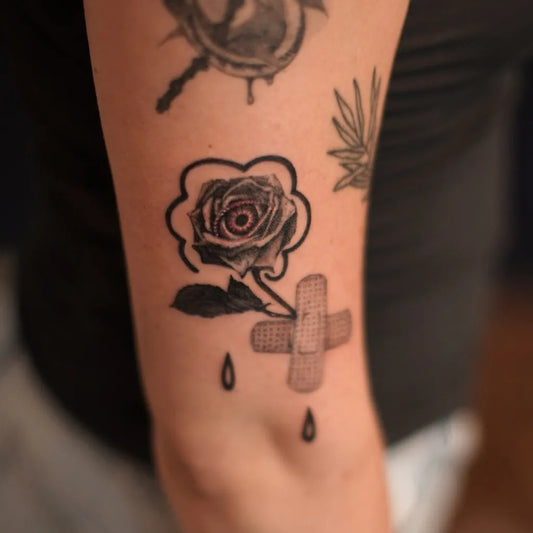Small Neotraditional Rose Bandages on Women Arm Tattoo by @iza.popek.tattoo
