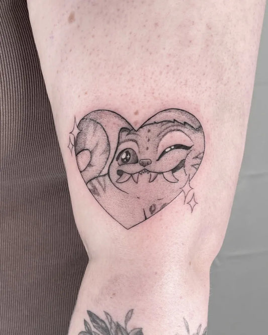 Small Neotraditional StitchHeartCartoon Tattoo on Women Arm by @acat.tats