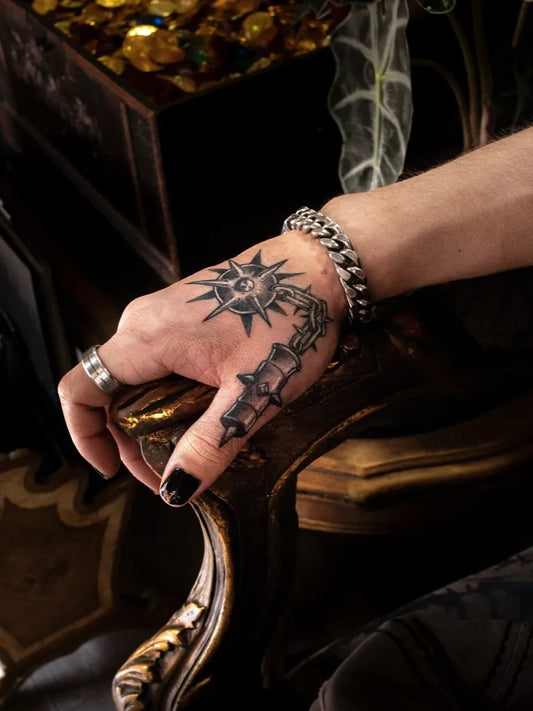 Small Neotraditional Sun and Anchors on Men Hand Tattoo by @lapirateriatattoovalencia