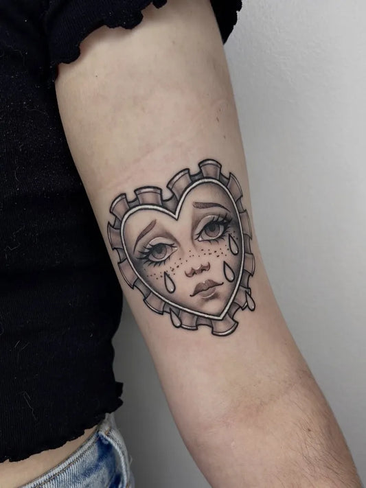 Small New School Heart with Crying Face on Women Arm Tattoo by @heartcruz