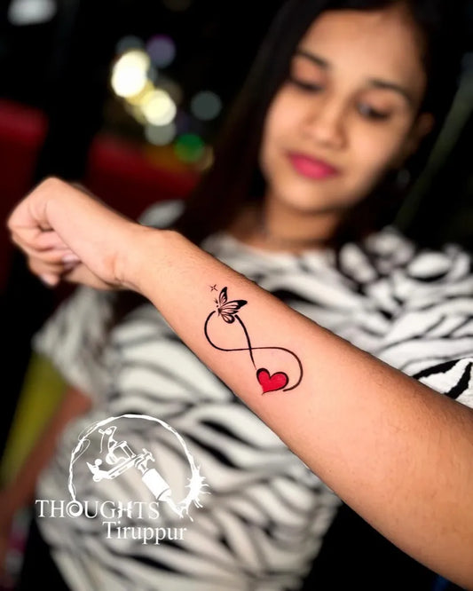 Small New School Infinity Heart Butterfly Tattoo on Women Wrist by @thoughts_tattoo_tirupur