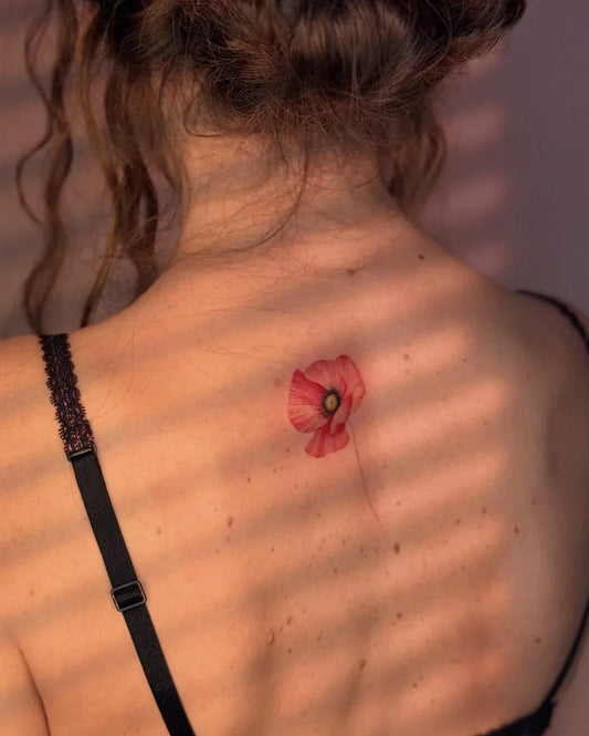 Small New School Poppy Tattoo on Women Back by @eva_tattooist