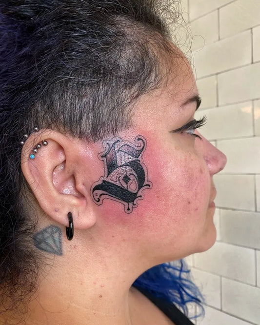 Small Old English B and Diamond on Women Face Tattoo by @rizza_boo