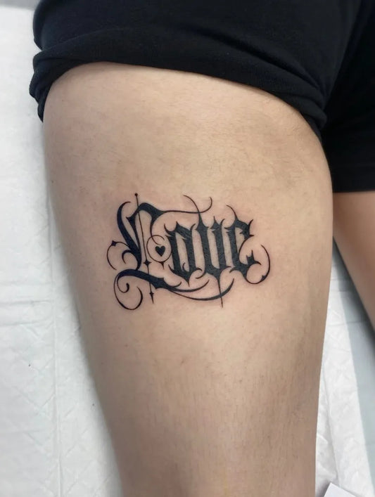 Small Old English Love on Women Thigh Tattoo by @sandra.o.tattoo