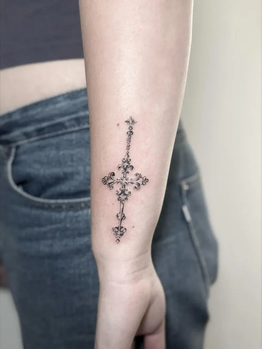 Small Ornamental Cross Floral on Women Wrist Tattoo by @aino.tattoo