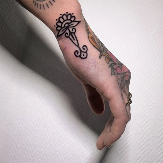 Small Ornamental Lotus Floral Tattoo on Women Wrist by @majk.thebad