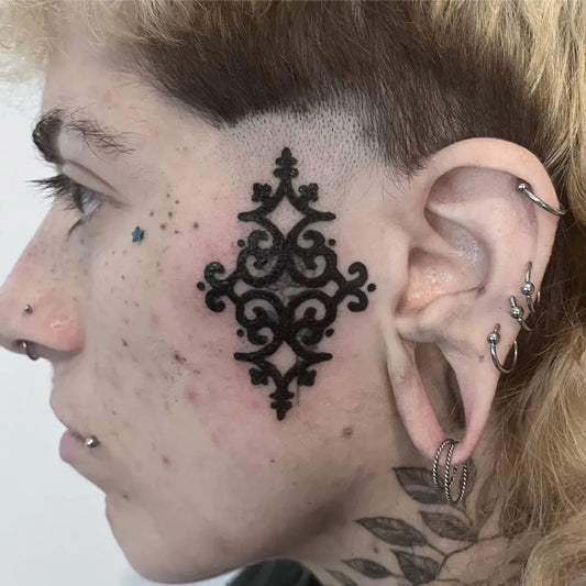 Small Ornamental Mandala on Women Face Tattoo by @ink.blot.project