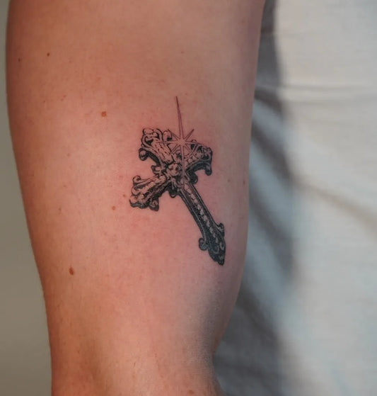 Small Ornate Cross on Men Arm Tattoo by @layers.cgn