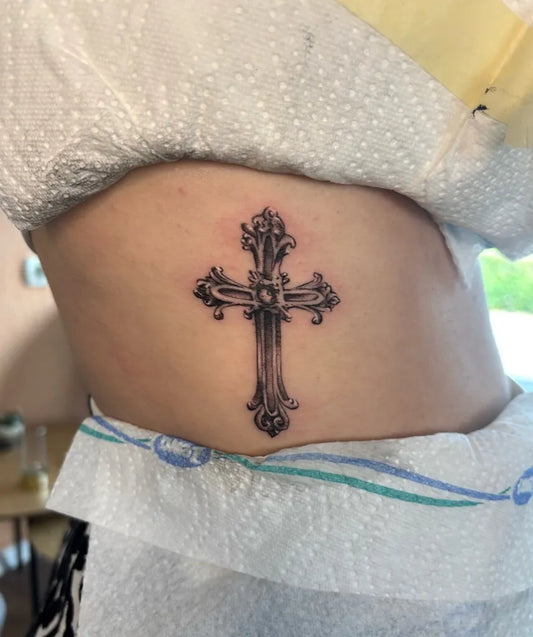 Small Ornate Cross on Women Side Tattoo by @roomcraft.tattoo