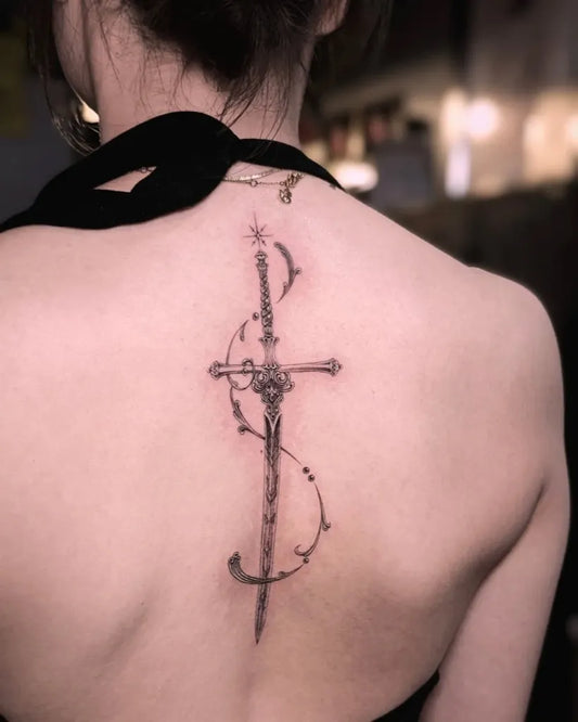 Small Ornate Sword and Cross on Women Spine Tattoo by @sunnymytattoo