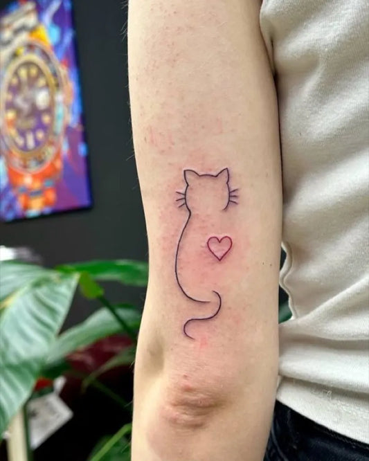 Small Outline Cat with Heart Tattoo on Women Arm by @goonsandqueens_enschede