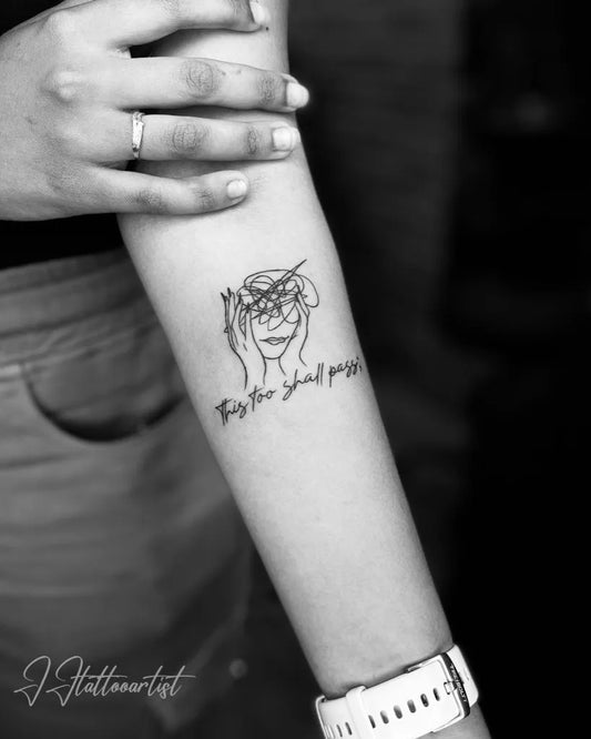 Small Outline FaceWithMessyLinesAndText Tattoo on Women Arm by @jjtattooartist