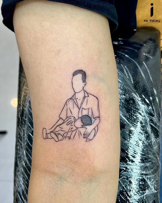 Small Outline Father Holding Child Tattoo on Men Arm by @ink_valley_tattoo