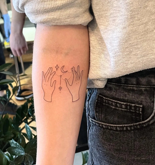 Small Outline Hands Moon Tattoo on Women Arm by @jessiethetattooartist