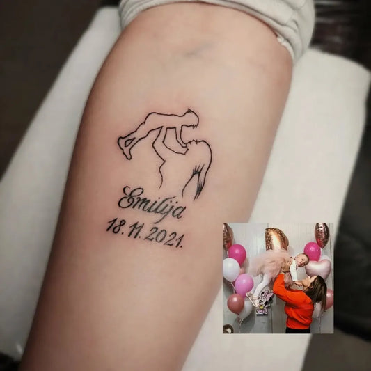 Small Outline Mother holding child with name and date Tattoo on Women Arm by @angel.ink_tattoo