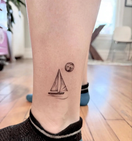 Small Outline Sailboat Moon Tattoo on Women Ankle by @jessiethetattooartist